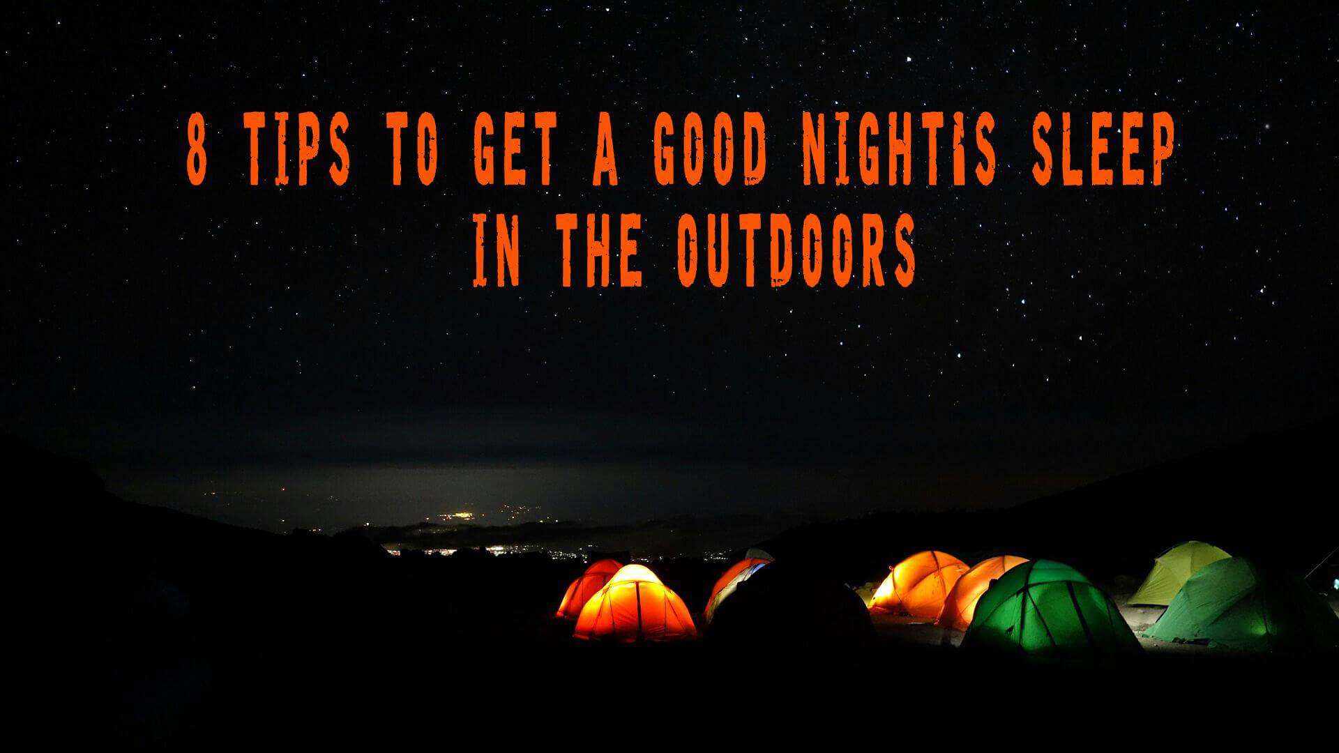 Group of illuminated tents on a plateau at night showing sleeping outdoors tips for warm, safe camping in the wildernes