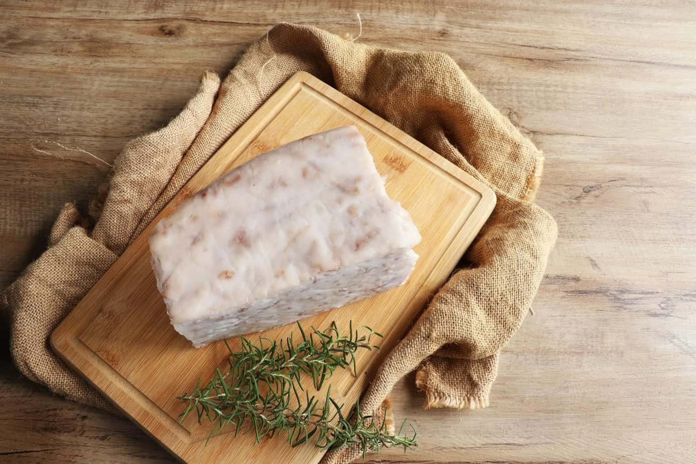 Tallow brick on a wooden board representing traditional European survival fats.